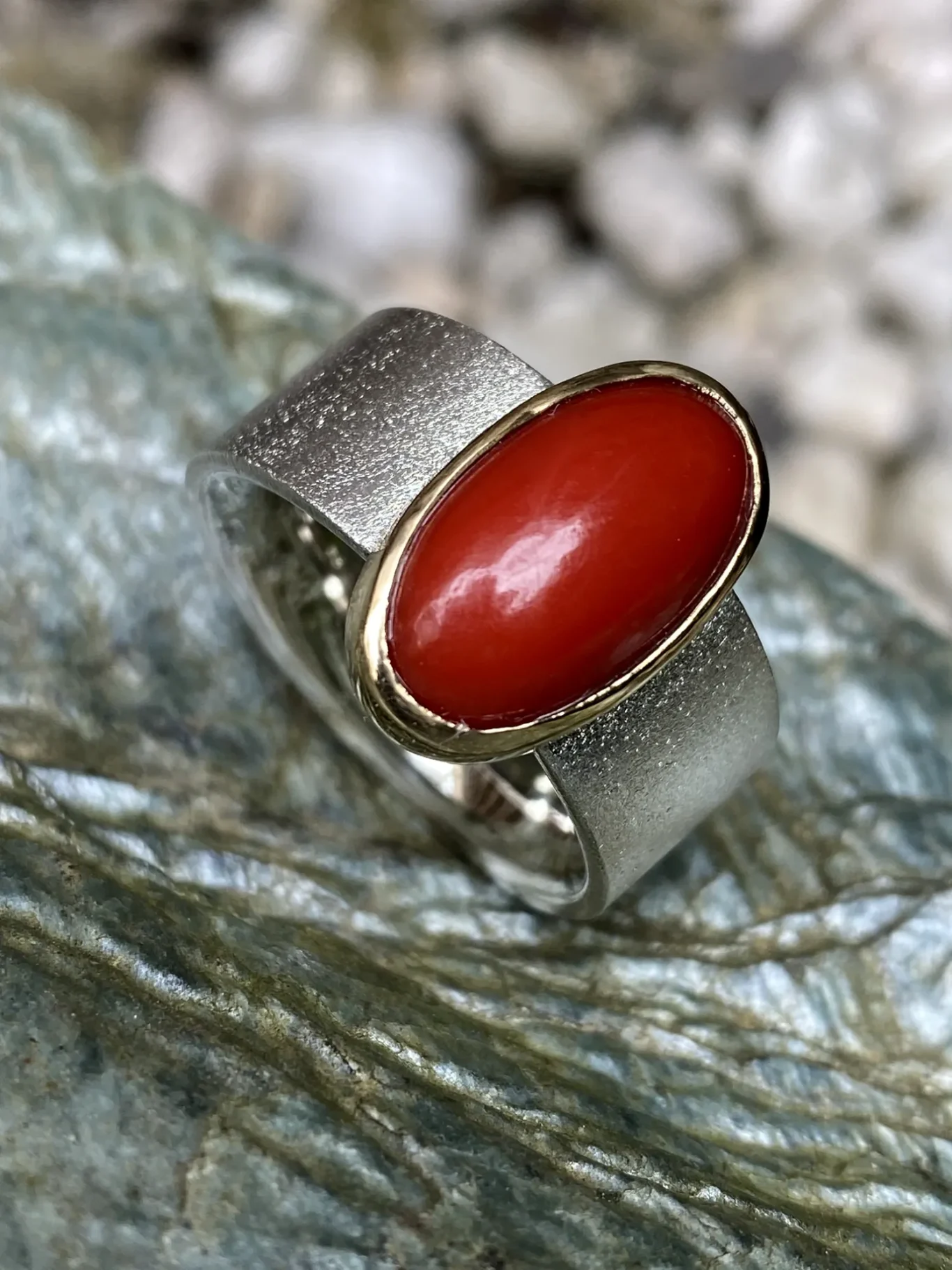 Ringe Silberring, mit ovaler Koralle gold eingefasst.